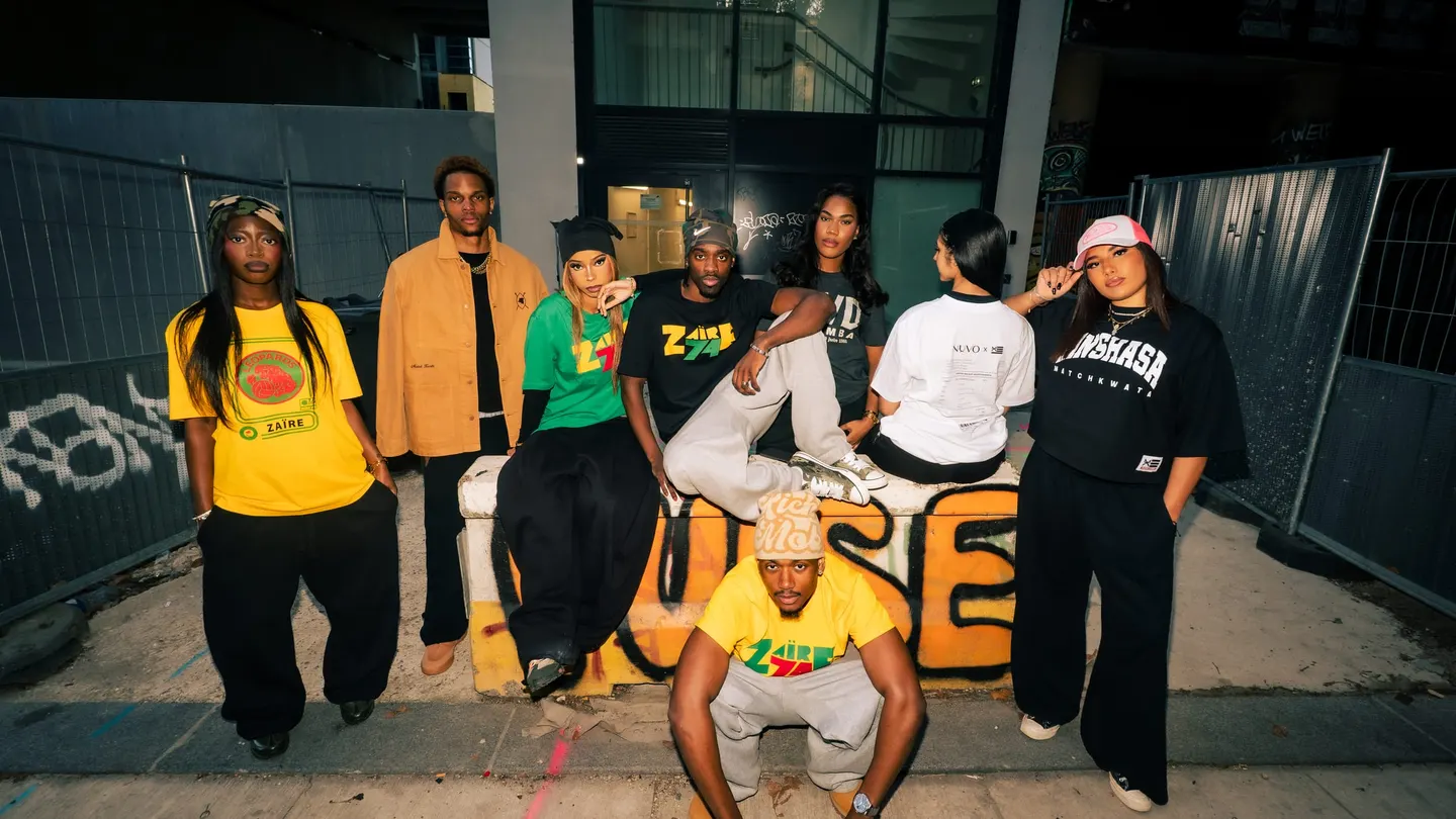 La bande Match Kwata réunie devant un mur graffé, en t-shirts Zaïre, Kinshasa et Match Kwata
